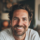 Homme souriant, intérieur chaleureux en arrière-plan.